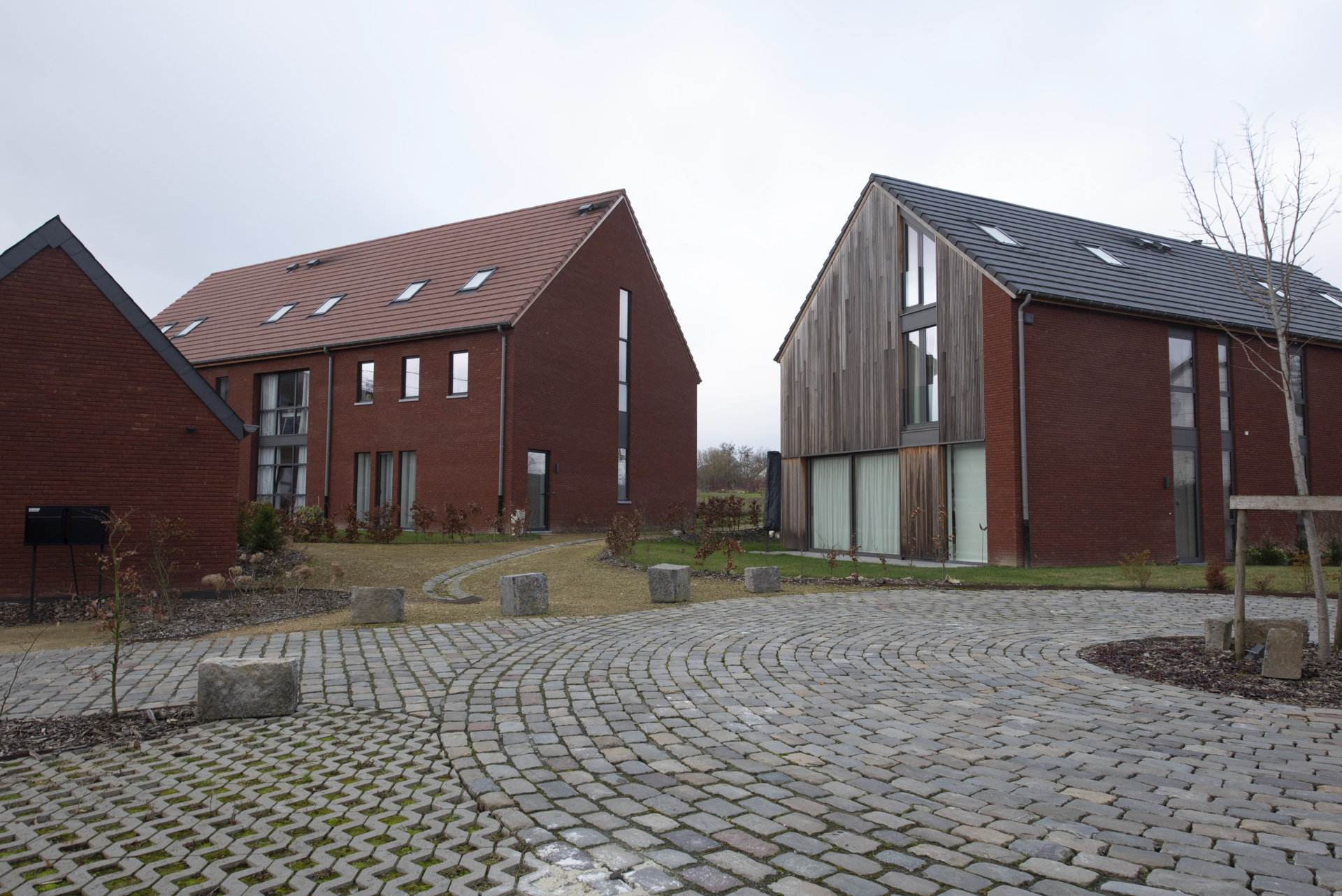 2 maisons en brique rouge et bardage de bois